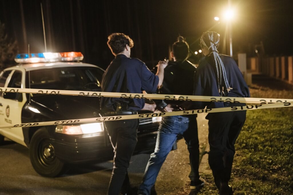 Person being taken into custody, illustrating the urgent middle-of-the-night searches criminal defense marketing must capture